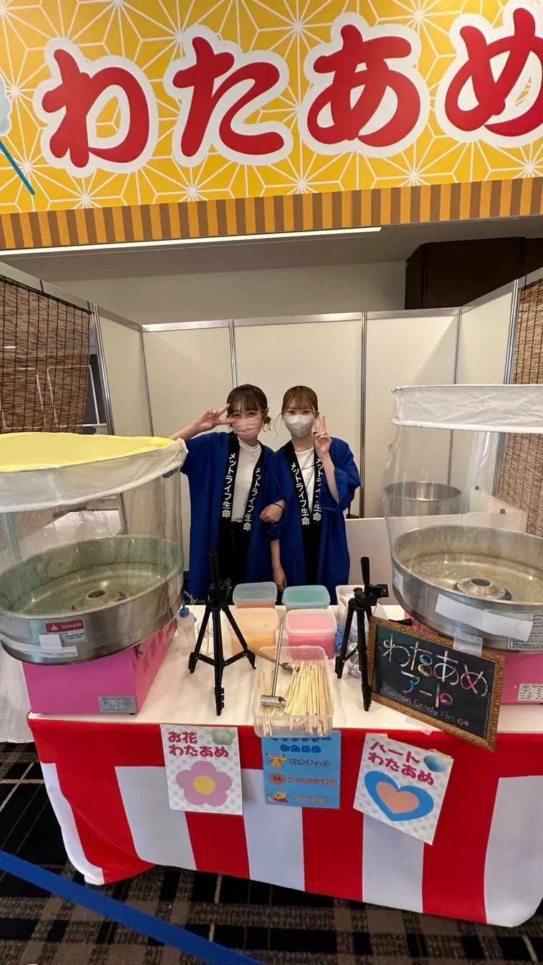 企業イベントの展示ブースでわたあめ機2台を設置したスタッフ